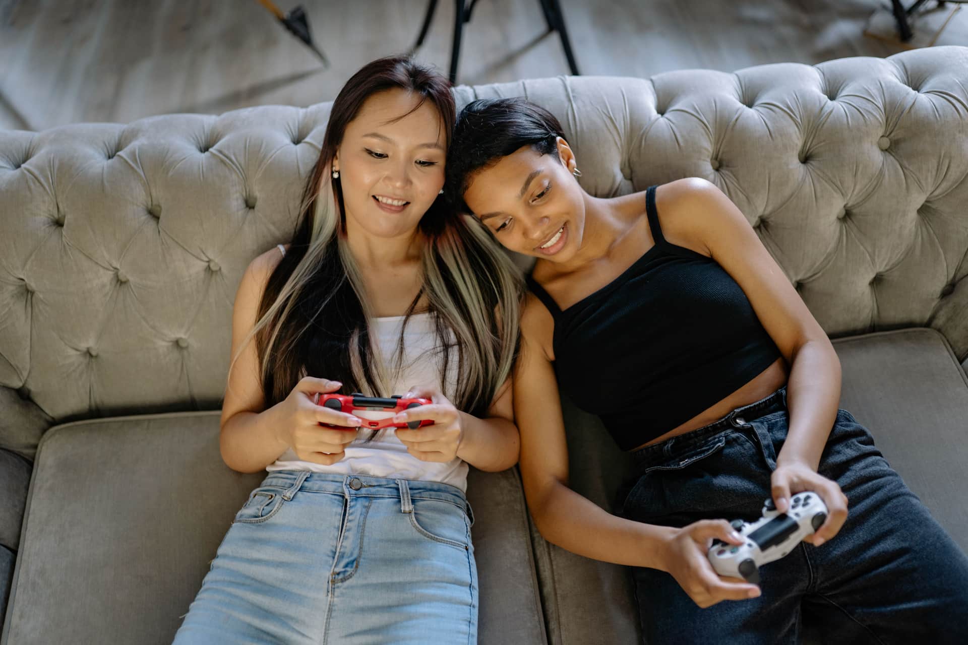 Friends playing video games together on a couch